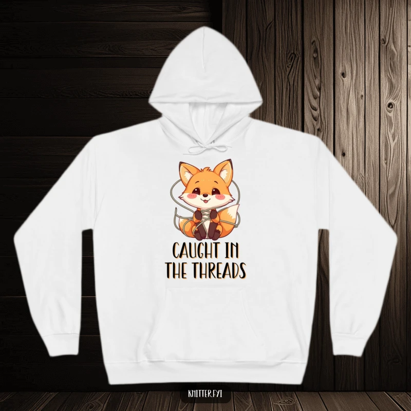 Funny Fox Hoodie with a playful fox character smiling while tangled in a web of colorful yarn, perfect for cozy crafters.